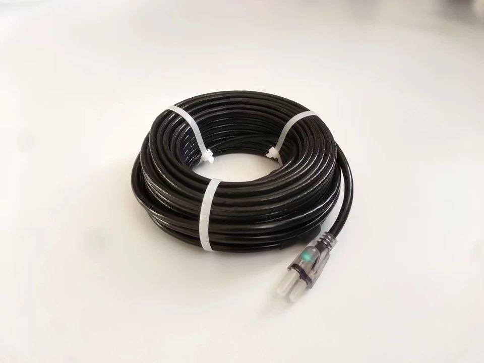 Coiled black heating cable with a molded power plug.